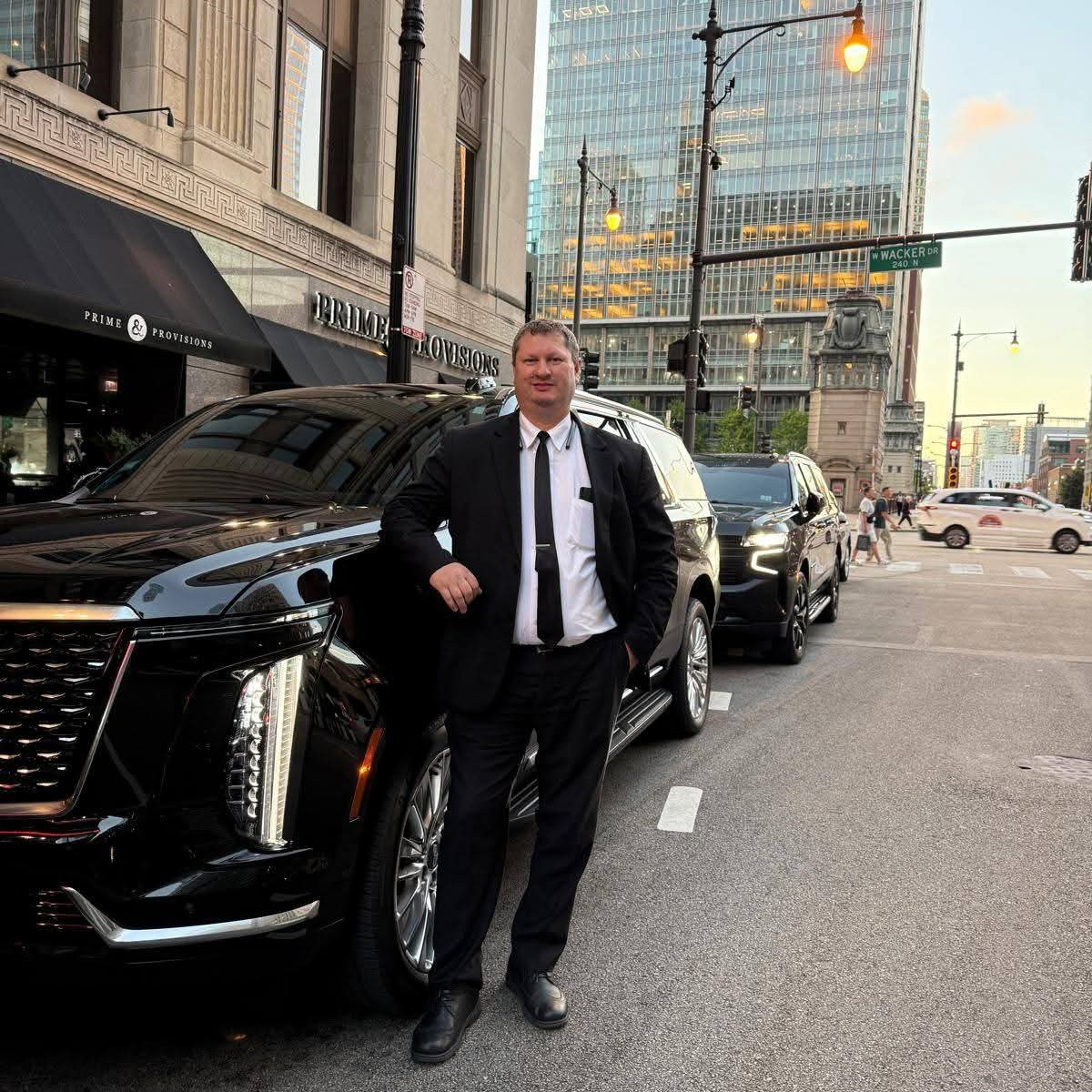 Senior executive chauffeur next to a black SUV in downtown Chicago
